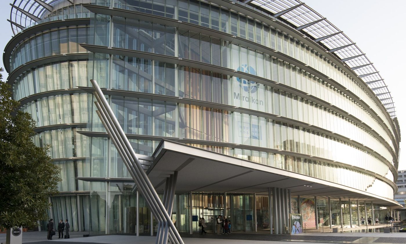 The curved glass facade of the Miraikan science museum in Odaiba, Tokyo