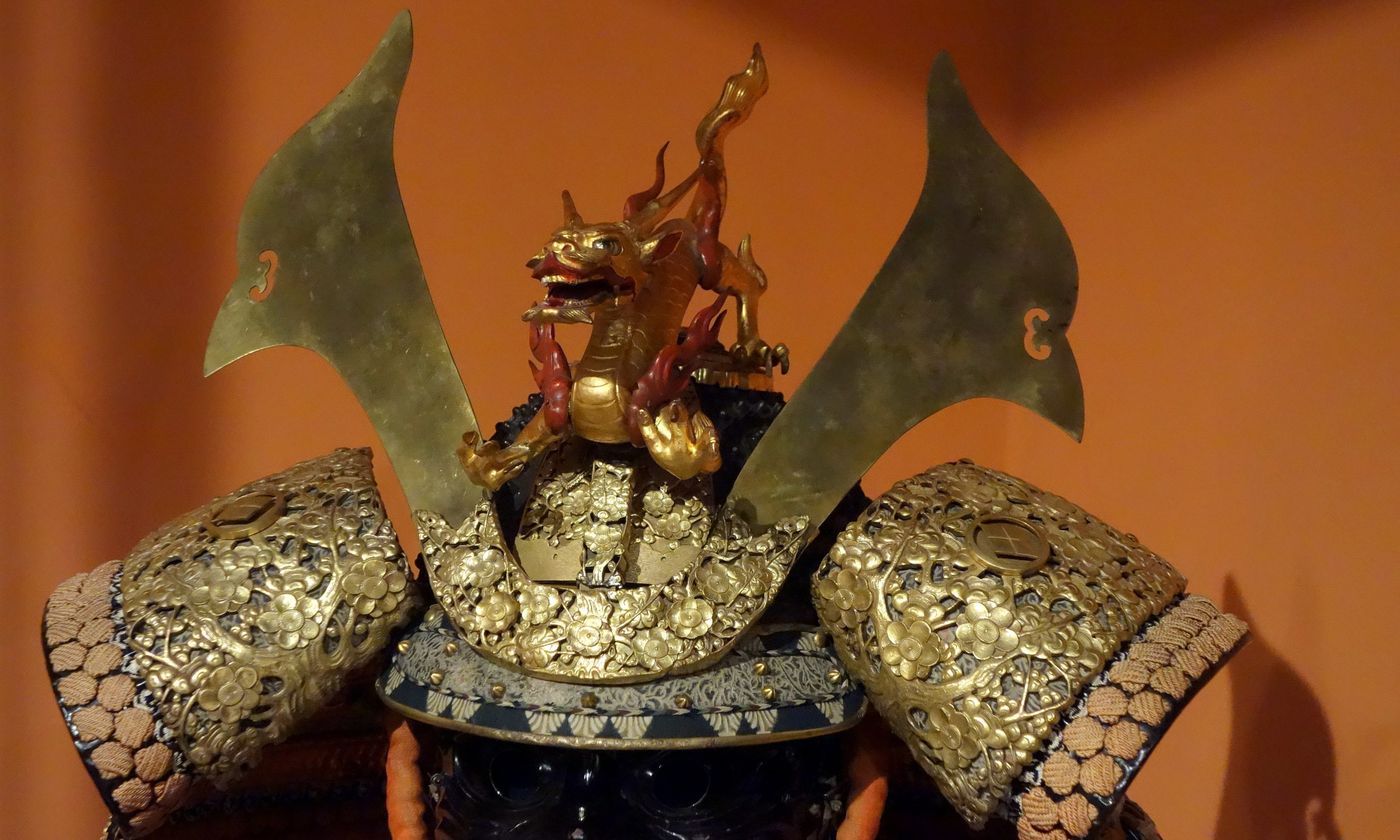 A gilded samurai helmet with a dragon crest and wide horns